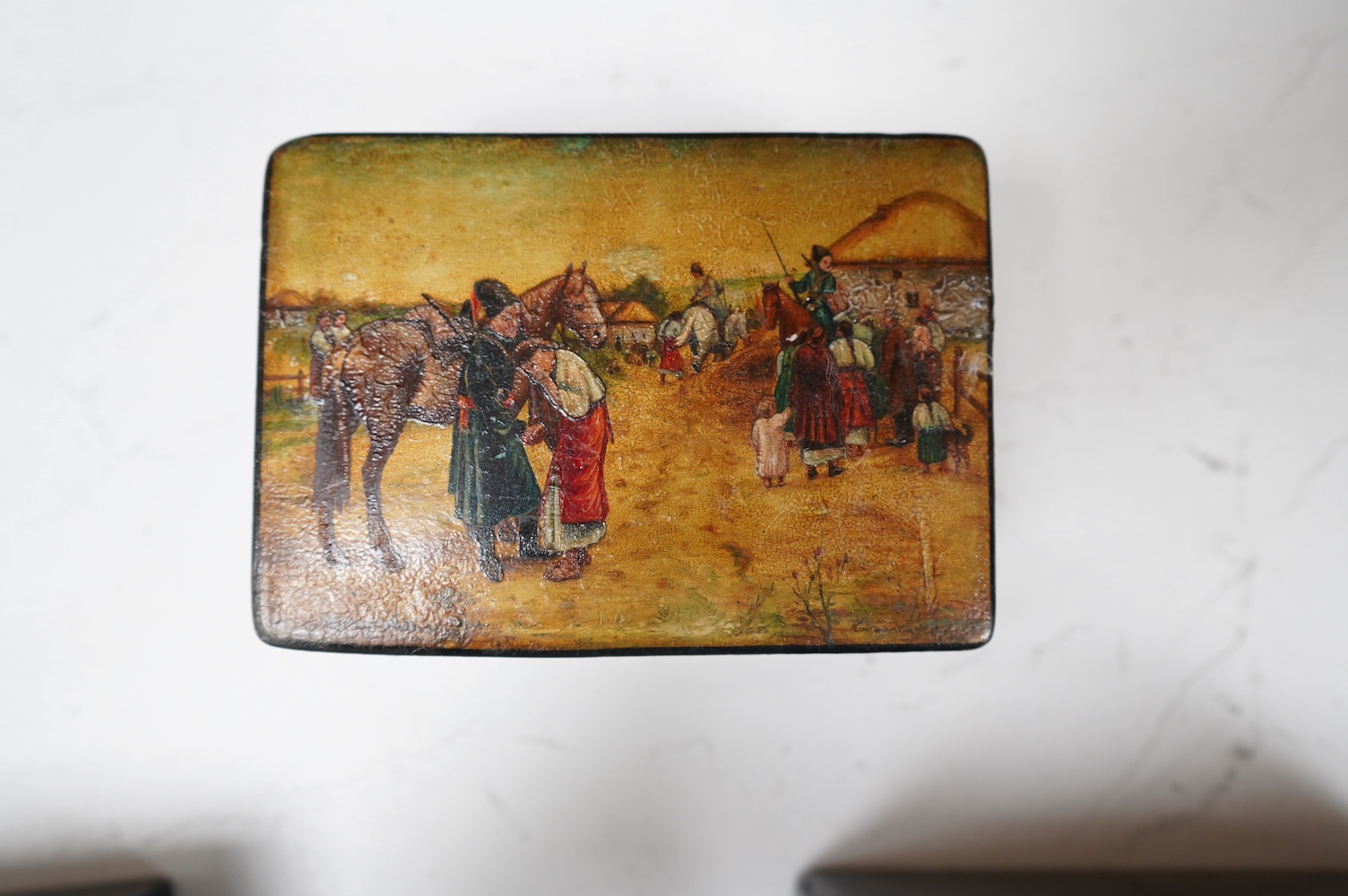 Three late 19th century Russian lacquer boxes, covers painted with Russian provincial scenes, largest14cm wide. Condition - varied